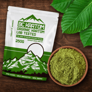 Green BC Kratom Bag laying on a wooden table next to a bowl of Green Kapuas Kratom Powder