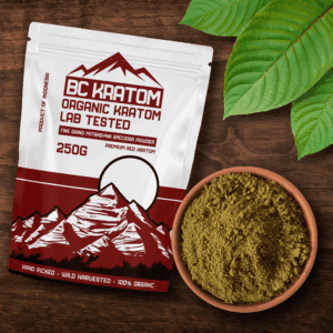 Red BC Kratom Bag laying in a wooden table next to a bowl of Red Sumatra Kratom Powder