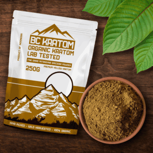 Gold BC Kratom Bag laying on a wooden table next to a bowl of Gold Kali Kratom Powder