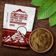 Red BC Kratom Bag laied on a table beside a bowl of Red Bentuangie Kratom Powder. There are kratom leaves in the corner